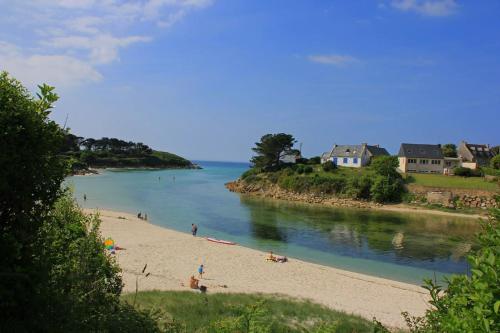 a group of people on a beach next to the water at Gite ty hent houarn in Landunvez