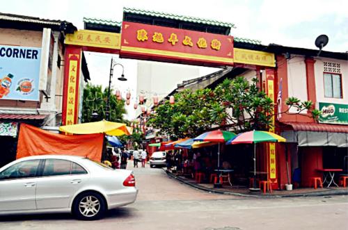 a white car driving down a city street with umbrellas at Hotel Legend Boutique in Johor Bahru
