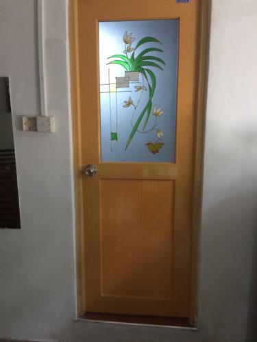 a door with a picture of a plant on it at Low budget pilgrim home in Anuradhapura
