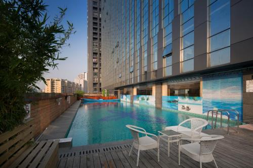 廣州的住宿－鴻德國際酒店，大楼内一个带两把椅子和一张桌子的游泳池