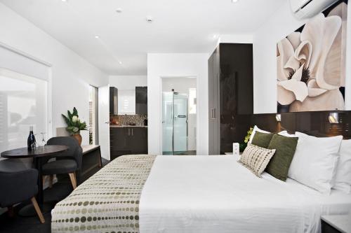 a bedroom with a large white bed and a desk at North Adelaide Boutique Stays Accommodation in Adelaide