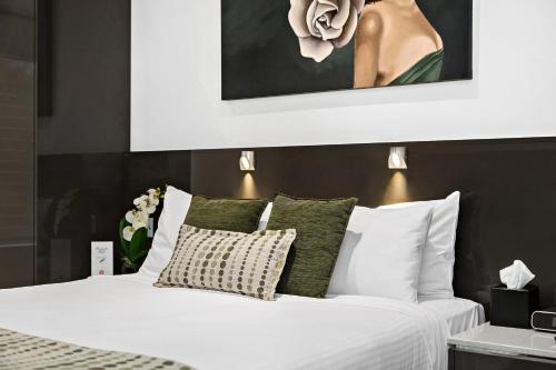 a white bed with a white comforter and pillows at North Adelaide Boutique Stays Accommodation in Adelaide
