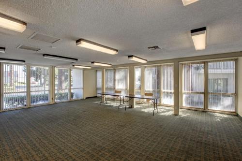 a large room with windows and a table and chairs at Motel 6-Santa Ana, CA - Irvine - Orange County Airport in Santa Ana
