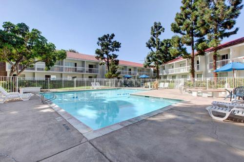 a swimming pool in front of a apartment building at Motel 6-Santa Ana, CA - Irvine - Orange County Airport in Santa Ana