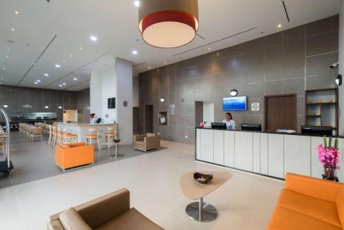 lobby szpitala z kobietą przy ladzie w obiekcie Best Western Plus Santa Marta Hotel w mieście Santa Marta