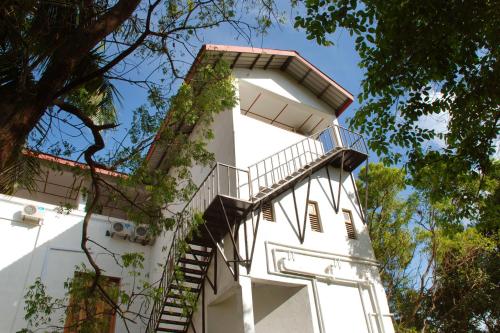 a white building with a staircase on it at The Triangle Hotel in Anuradhapura