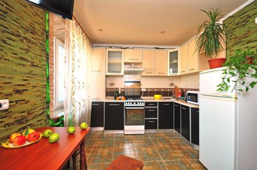 a kitchen with black cabinets and a table with fruits on it at Gagarina avenue in Kharkiv