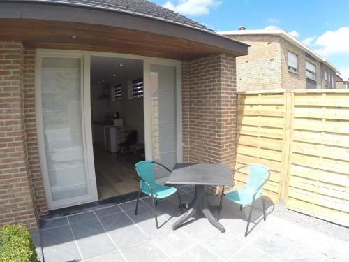a patio with a table and chairs on a patio at Le Lendemain in Lovendegem