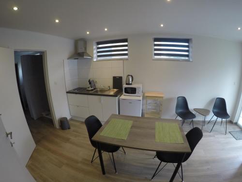 a kitchen and dining room with a table and chairs at Le Lendemain in Lovendegem