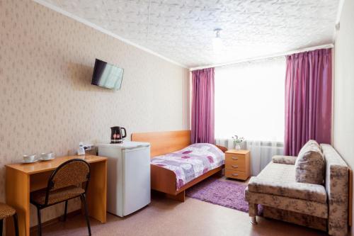 ブズルクにあるHotel Buzulukのベッドルーム1室(ベッド1台、デスク、椅子付)