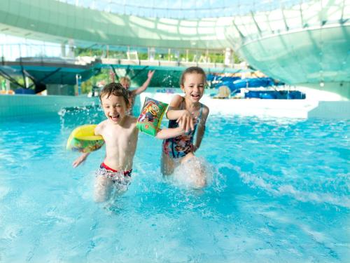 two young children playing in a swimming pool at Hotel Thermana Park Laško**** Superior in Laško