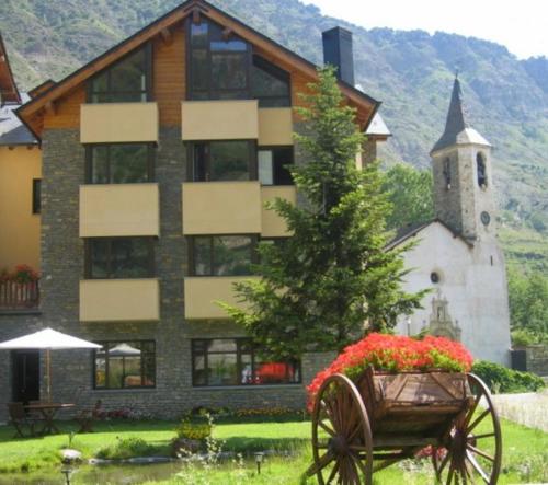 a building with a wagon with flowers in front of it at Roca Blanca in Espot