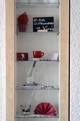 a shelf with dishes and other items on it at Vico's Hotel & Restaurant Asperg in Asperg