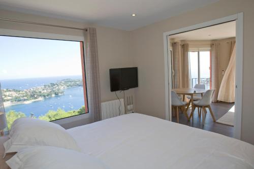 sypialnia z dużym białym łóżkiem i dużym oknem w obiekcie Le Rooftop 180 w mieście Villefranche-sur-Mer