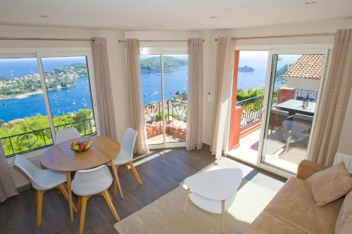 a living room with a table and views of the ocean at Le Rooftop 180 in Villefranche-sur-Mer
