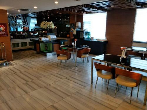 un restaurante con suelo de madera, mesas y sillas en Goldmet Inn Taiyuan Dananamen en Taiyuán