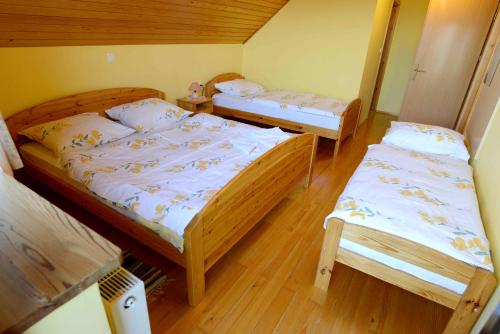 two twin beds in a room with wooden floors at Apartment House Koprivnik in Zreče