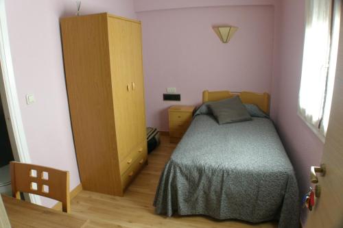 a small bedroom with a bed and a cabinet at Hostal Restaurant Jose Luis in Trespaderne