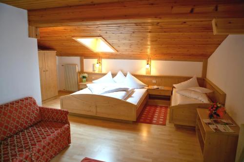 ソルダにあるGarni Olympiaの大きなベッドとソファが備わる広い客室です。