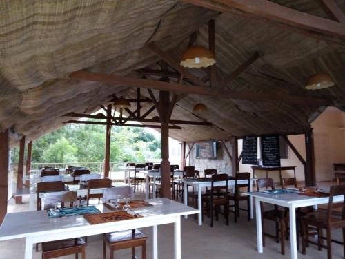 a dining room with wooden ceilings and tables and chairs at Hotel Chez Fanny in Palimé