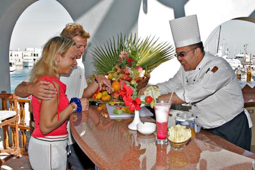 um grupo de pessoas em pé em torno de uma mesa com um chef em Three Corners Ocean View El Gouna - Adults Only em Hurghada