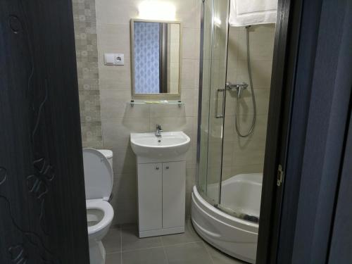 a bathroom with a toilet and a sink and a shower at Art Hotel Palma in Lviv