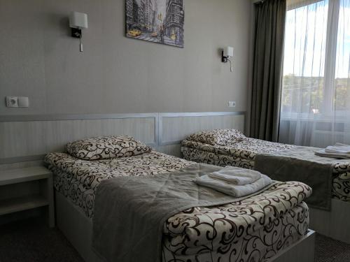 a hotel room with two beds and a window at Art Hotel Palma in Lviv