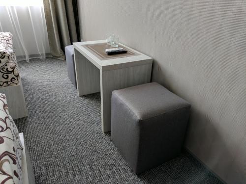 a small table with a stool and a wine glass on it at Art Hotel Palma in Lviv