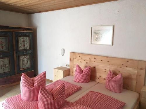 ein Zimmer mit einem Bett mit rosa Kissen darauf in der Unterkunft Tiefhof in Nauders