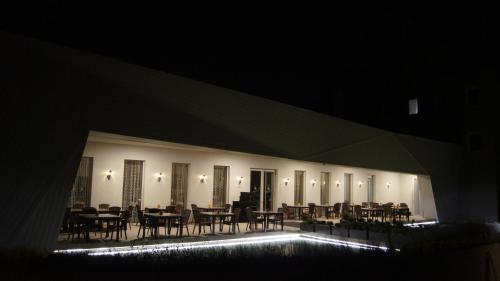 a dining room with tables and chairs at night at Anna Hotel in Budapest