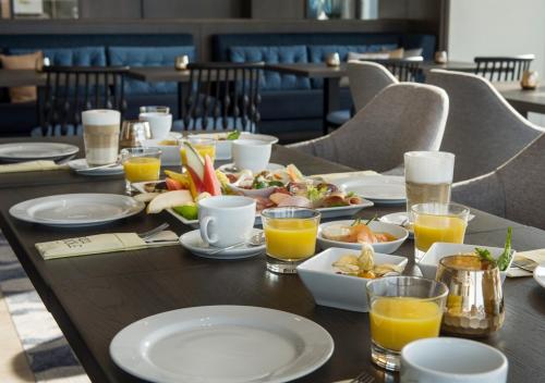 a table with plates of food and glasses of orange juice at Hotel Am Leuchtturm in Warnemünde