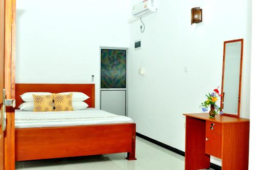 a bedroom with a bed with a mirror and a dresser at Nethmi Villa in Bentota