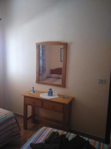 a bedroom with a table and a mirror on the wall at Casa Cira in Calera