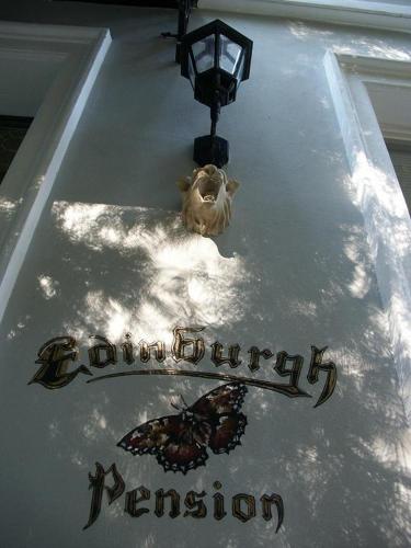 a butterfly sitting on top of a table with a sign at Edinburgh in Mariánské Lázně