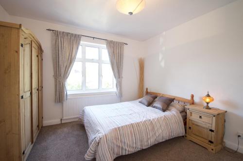 1 dormitorio con cama y ventana en Barnet 3 Bedroom House, en Londres