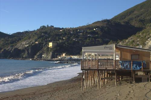 a building on a beach next to the ocean at Affittacamere Il Borgo in Levanto
