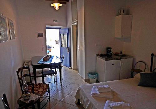 a room with a kitchen and a table and a room with a bed at Chora View in Kýthira