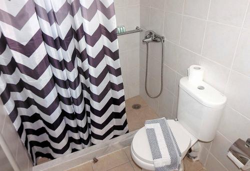 a bathroom with a toilet and a shower curtain at Chora View in Kýthira