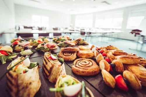 a table topped with different types of pastries and pies at Hotel Vivaldi in Poznań