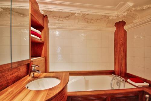 a bathroom with a sink and a bath tub at Alfred de Vigny in Paris