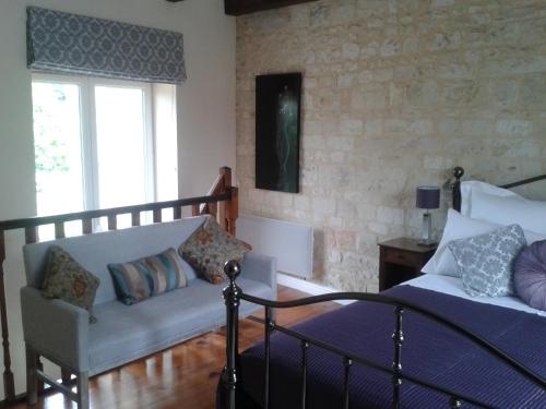 ein Schlafzimmer mit einem Bett und einer Couch in der Unterkunft La Maison Tumtum Arbre in Loudun