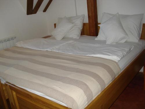 a large bed with white sheets and pillows at Villa Una in Sarajevo
