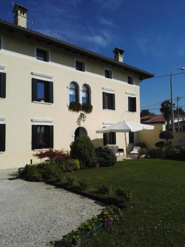 a large white house with a lawn in front of it at Casa Zanier Aviano in San Martino