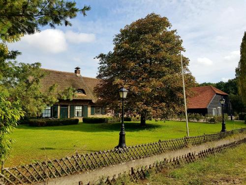 a house with a fence and a street light in front at Schaluinenhoeve in Baarle-Nassau