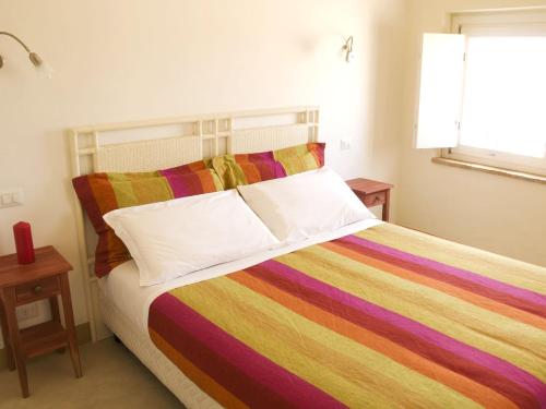 a bed with a colorful blanket on top of it at Tenuta San Marcello in San Marcello