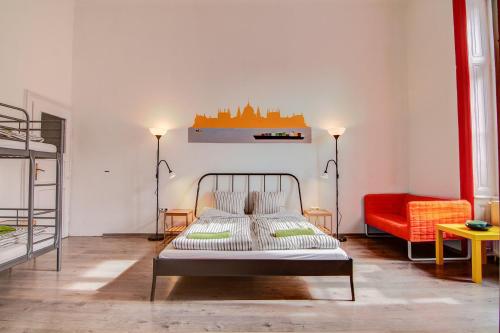 ブダペストにあるパルズ ミニ ホステルのベッドルーム1室(ベッド1台、赤いソファ付)