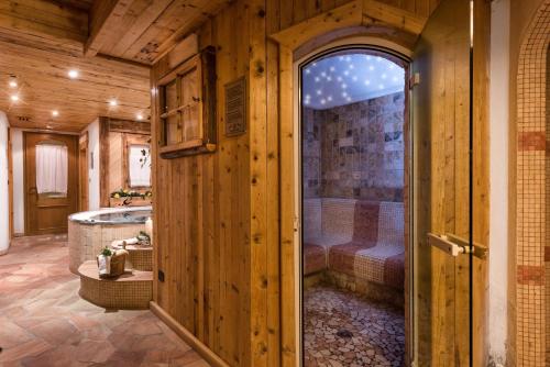 un ingresso a una camera con bagno dotato di vasca di Romantic Charming Hotel Rancolin a Moena