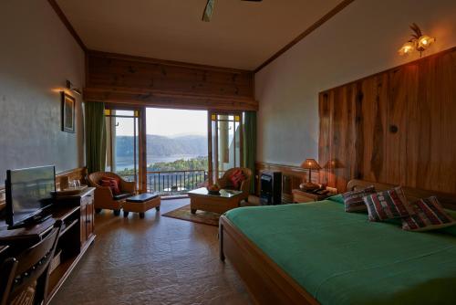 a bedroom with a green bed and a large window at Ri Kynjai Serenity by The Lake in Shillong