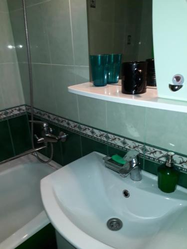 a bathroom with a white sink and a mirror at Apartment on Gatchinskaya in Saint Petersburg