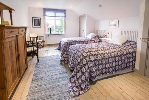a hotel room with two beds and a window at Eneby Gård Apartments in Sköldinge